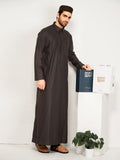 Man wearing a long dark brown robe holding a hijazi product box on a white background