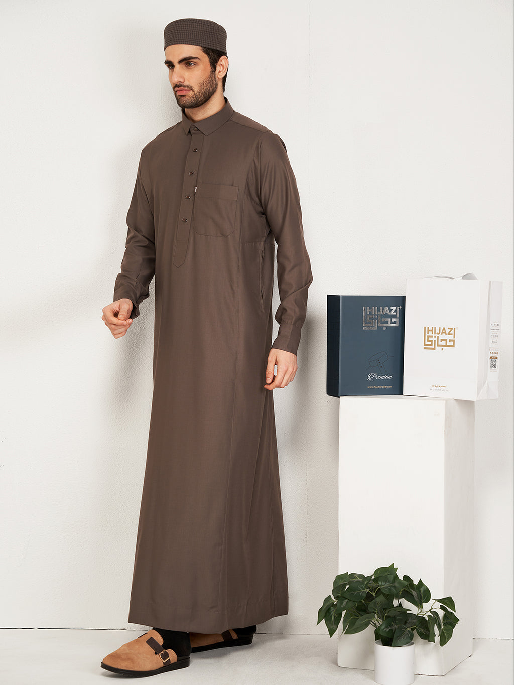 Man wearing a brown traditional outfit with a white background