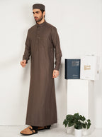 Man wearing a brown traditional outfit with a white background