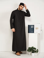 Man wearing a black thobe with a white background