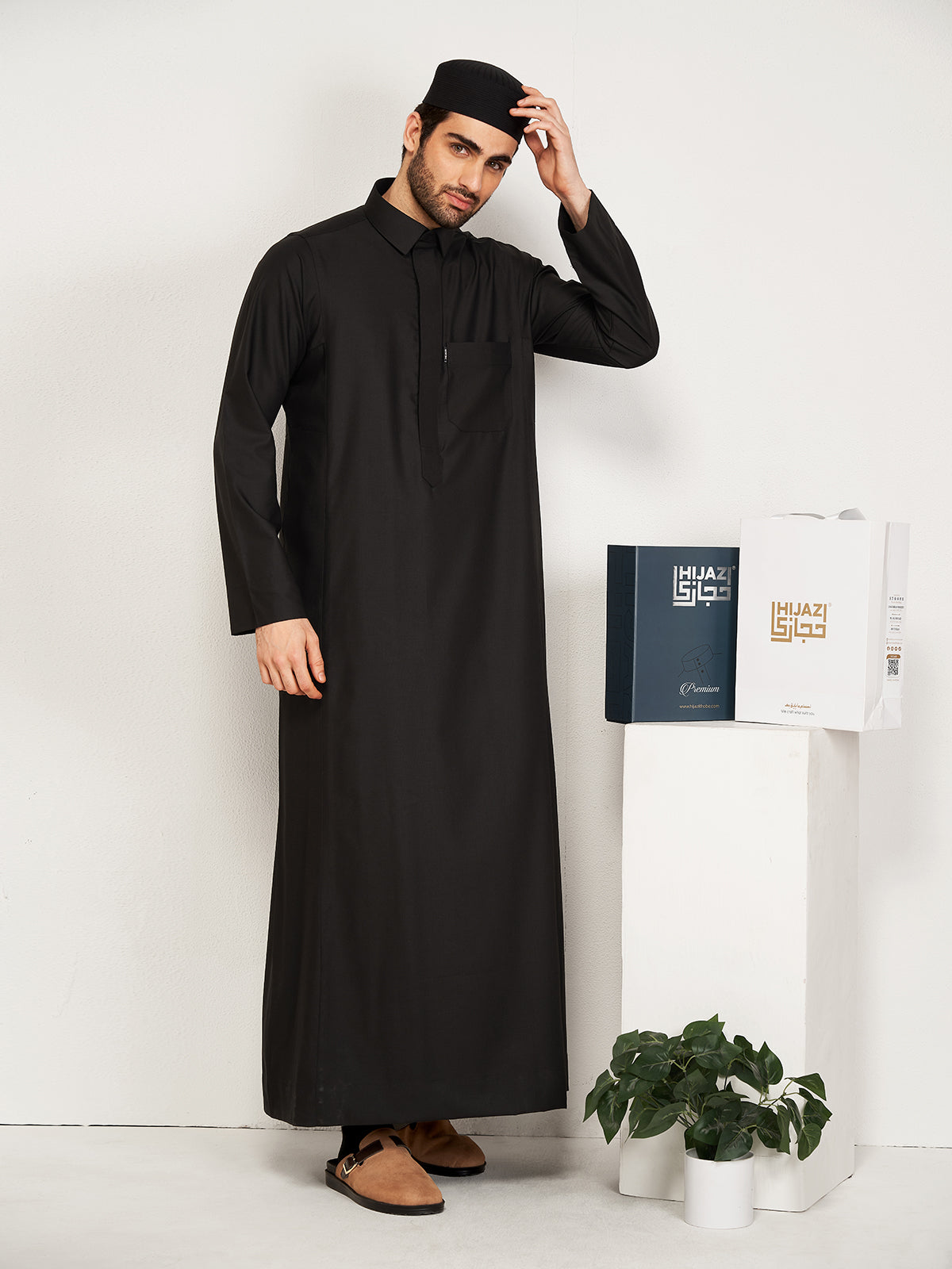 Man wearing a black thobe with a white background