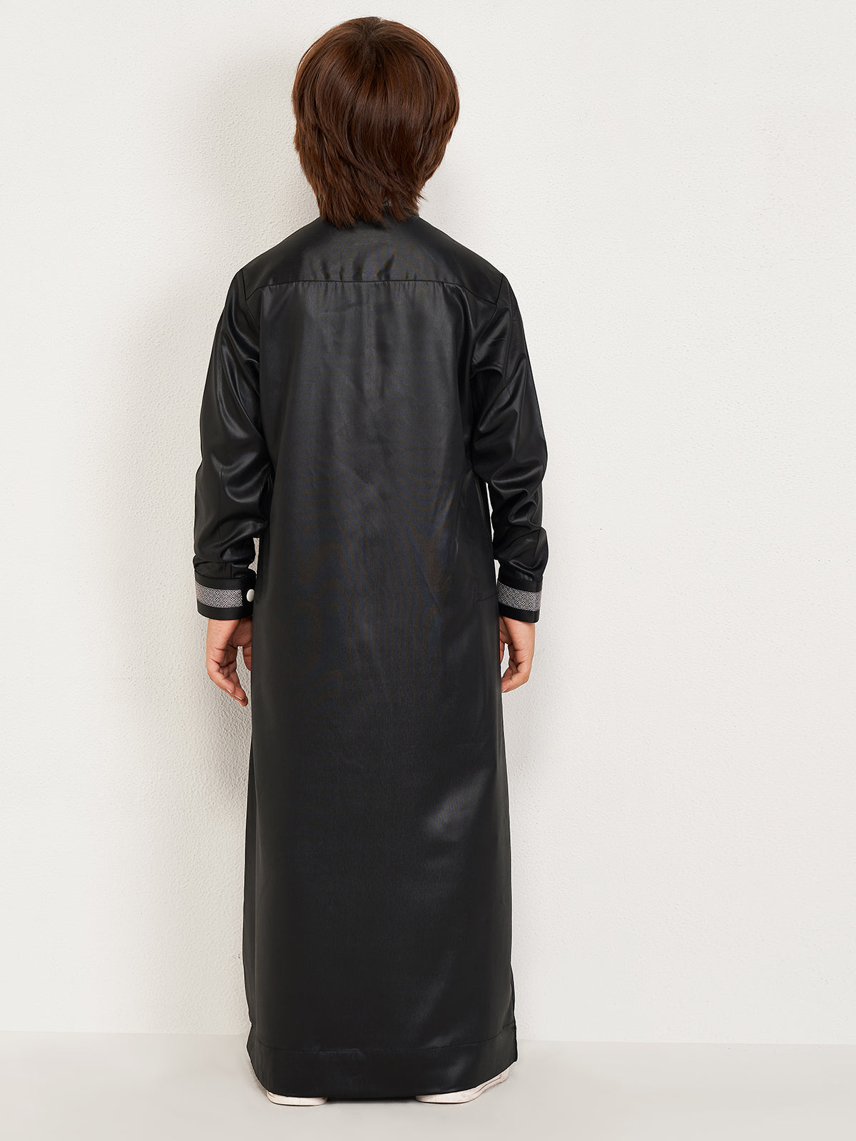 Person wearing a long black leather dress on a white background
