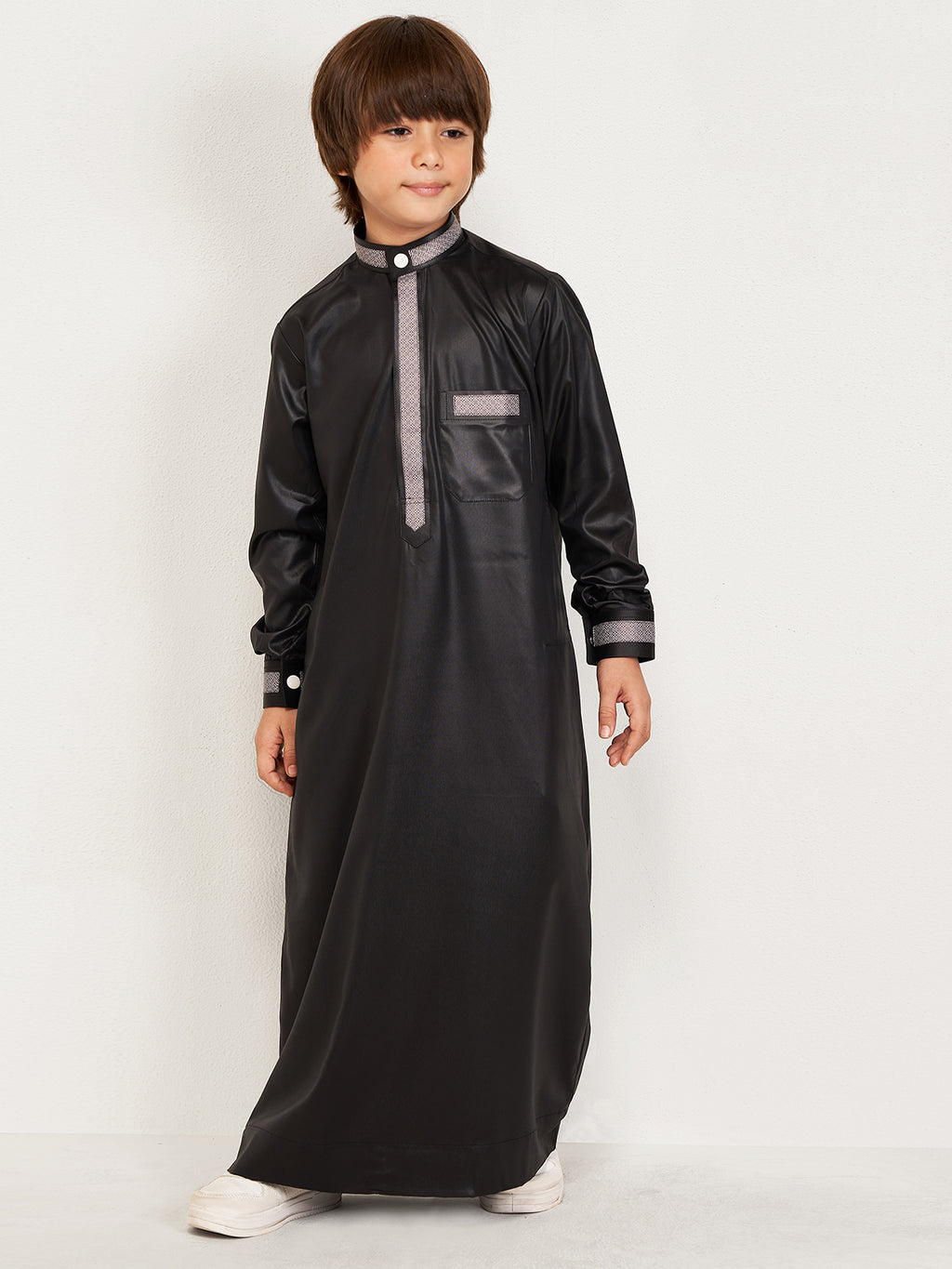Child wearing a black traditional outfit with a white background