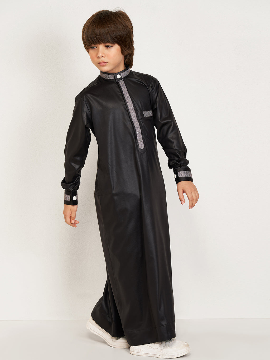 Child wearing a black formal outfit with gray accents on a white background